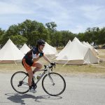 biker riding past bell tents