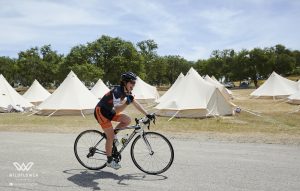 biker riding past bell tents