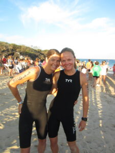 Jen Temperley and Robin White wetsuit shot on beach