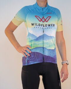 Woman modeling the 2026 Wildflower Experience cycling jersey by Zoot