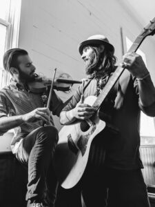 black and white photo of the Cimo Brothers palying the fiddle and the guitar.